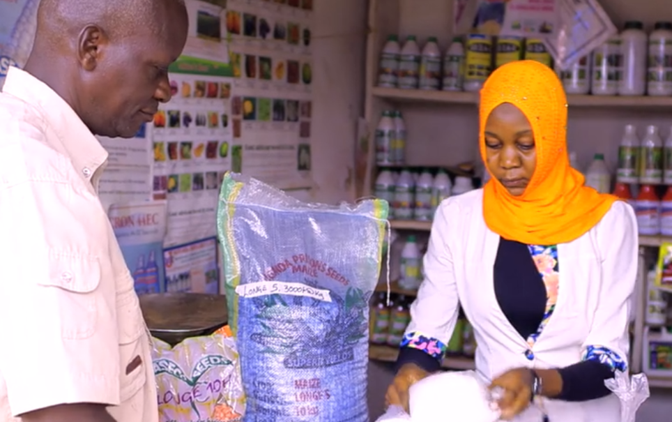 A customer, left, buys seed from an agro-dealer in Uganda. Women in Uganda manage a significant share of agro-input shops, yet research shows they face disadvantages in bargaining over prices.